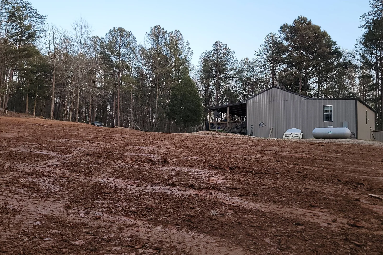 Cleared and graded lot beside a metal building on a North Alabama job