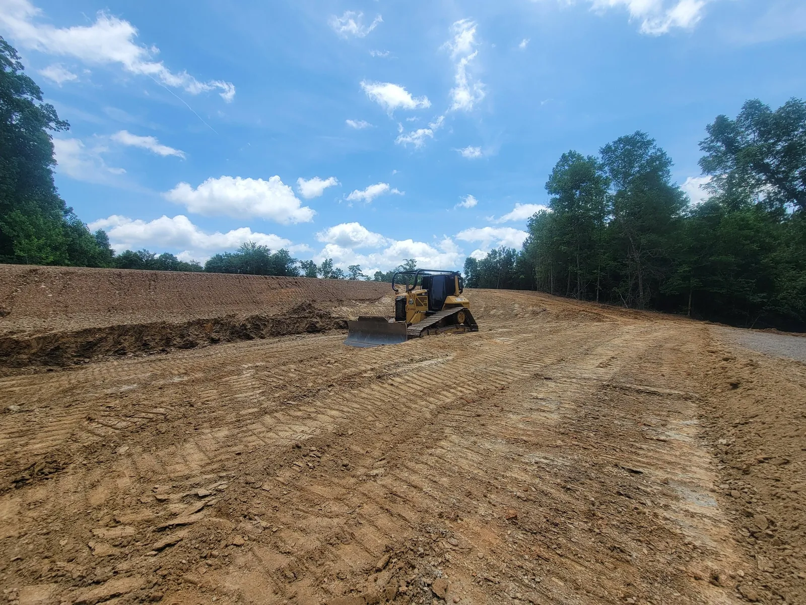 Dozer shaping a new drive and pad on a steady grade so water runs off