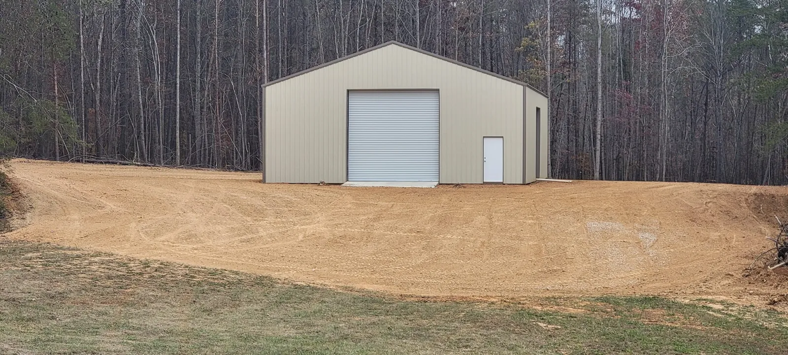 Finish grading around a new metal shop, slopes dressed and the pad set to drain